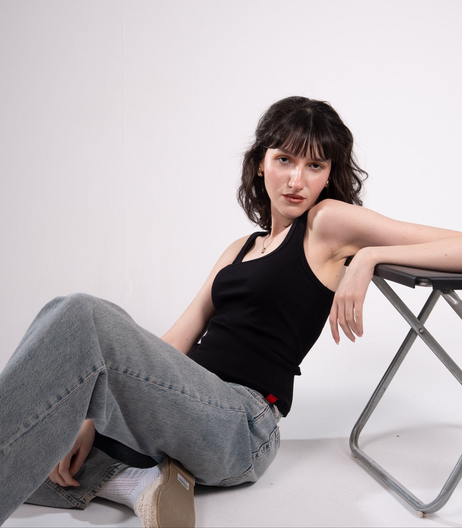 Woman sitting on a white floor with a white background